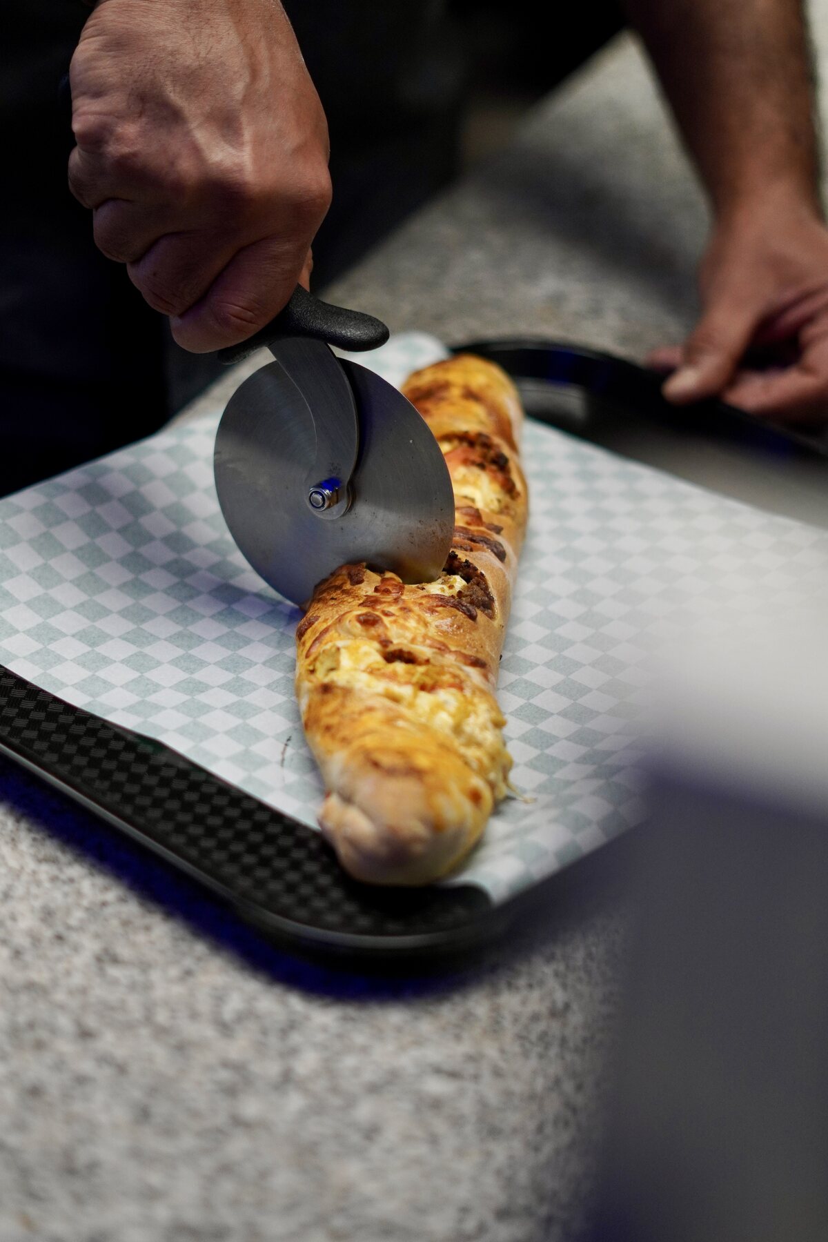 A freshly baked stuffed baguette being sliced